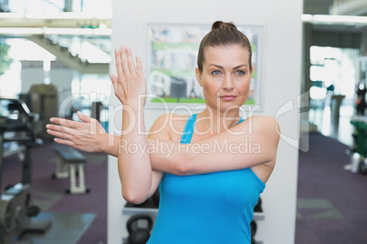 Fit brunette warming up in fitness studio