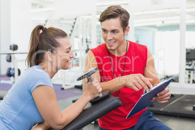 Personal trainer working with client holding dumbbell