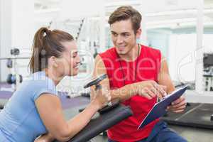 Personal trainer working with client holding dumbbell