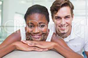 Personal trainer and client smiling at camera with exercise ball