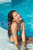 Cheerful young woman by swimming pool