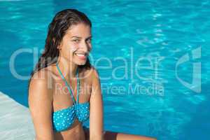 Beautiful young woman by swimming pool