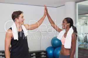 Personal trainer and client high fiving