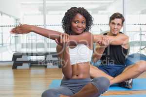 Fit couple warming up on exercise mats