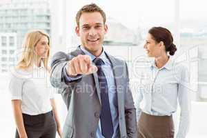 Businessman with colleagues behind at office