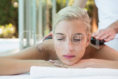 Beautiful woman receiving stone massage at health farm