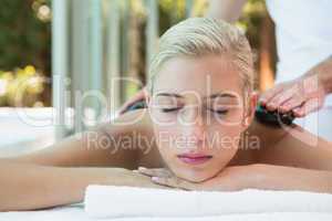 Beautiful woman receiving stone massage at health farm