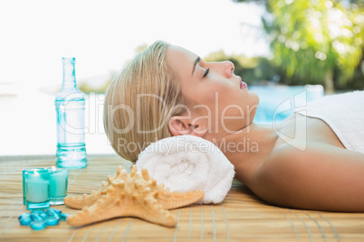 Beautiful woman lying on massage table at spa center