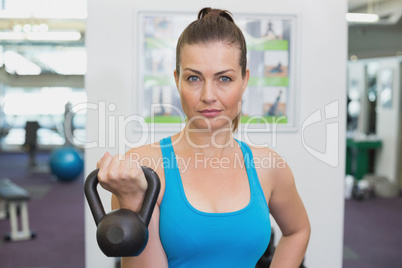 Fit brunette working out with kettlebell