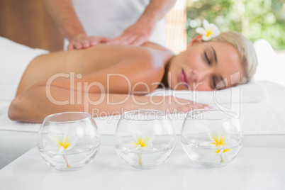 Woman receiving back massage at spa center