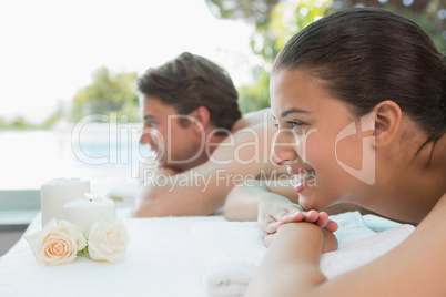 Couple lying on massage table at spa center