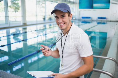 Handsome swimming instructor smiling at camera