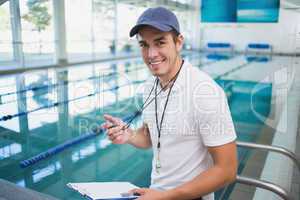 Handsome swimming instructor smiling at camera