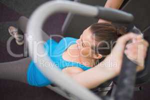 Fit brunette using weights machine for arms