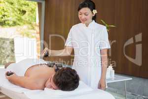 Man receiving stone massage at spa center