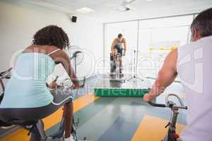 Spin class working out with motivational instructor