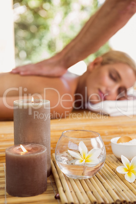 Woman receiving back massage at spa center