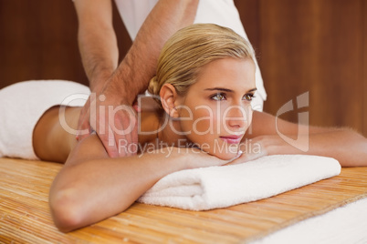 Woman receiving shoulder massage at spa center