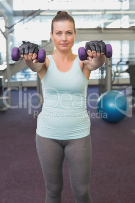 Fit brunette working out with dumbbells
