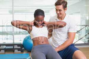 Personal trainer working with client on exercise ball