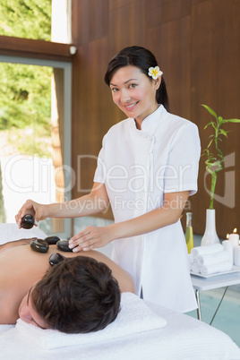 Man receiving stone massage at spa center