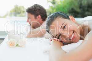 Couple lying on massage table at spa center