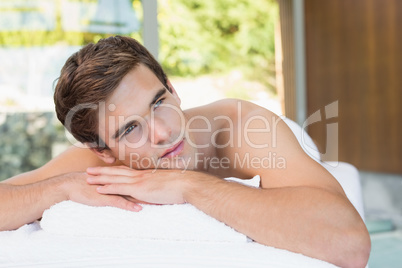 Man lying on massage table at spa center