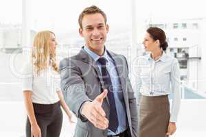 Businessman with colleagues behind at office