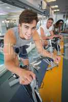 Three fit people working out on exercise bikes