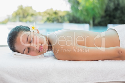 Beautiful woman lying on massage table at spa center