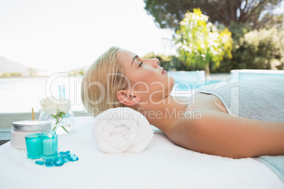 Beautiful woman lying on massage table at spa center