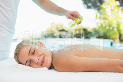 Woman receiving back massage at spa center