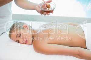 Woman receiving spa treatment with honey