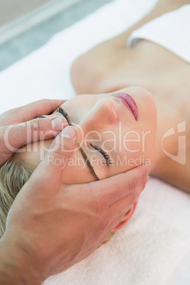 Attractive woman receiving head massage at spa center