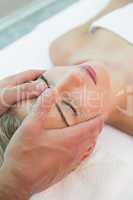 Attractive woman receiving head massage at spa center