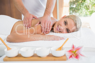 Woman receiving shoulder massage at spa center