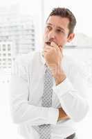 Thoughtful businessman looking away at office