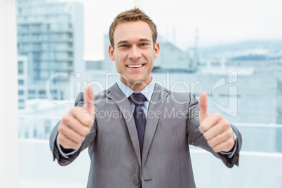 Businessman gesturing thumbs up in office