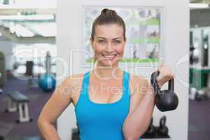 Fit brunette working out with kettlebell