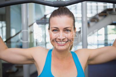 Fit brunette using weights machine for arms