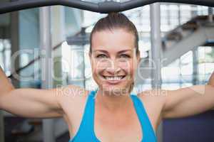 Fit brunette using weights machine for arms