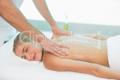 Woman receiving back massage at spa center