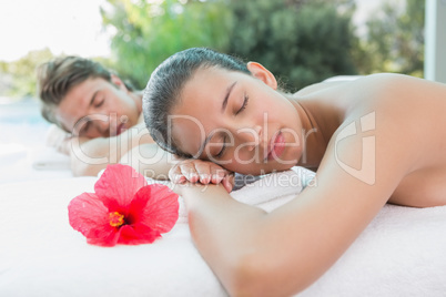 Couple lying on massage table at spa center