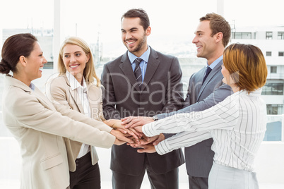 Executives holding hands together in office