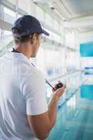 Swimming instructor holding stopwatch by the pool