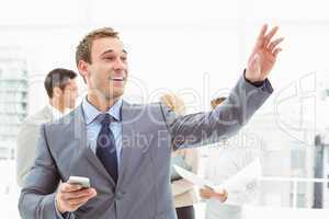 Businessman text messaging with colleagues in meeting behind