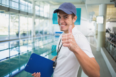 Swimming instructor smiling at camera by the pool