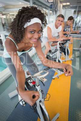 Three fit people working out on exercise bikes