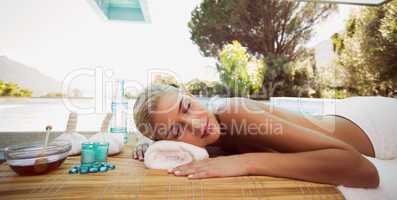 Beautiful woman lying on massage table at spa center