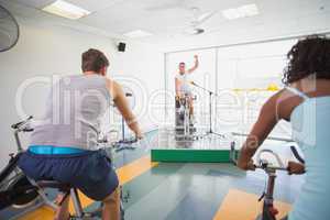 Spin class working out with motivational instructor